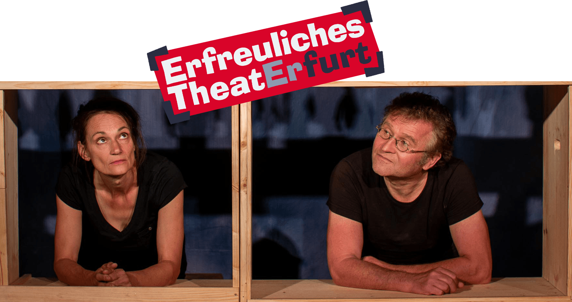 Katrin Heinke und Ronald Mernitz schauen durch hölzerne Rahmen auf das Logo des "Erfreuliches Theater Erfurt"